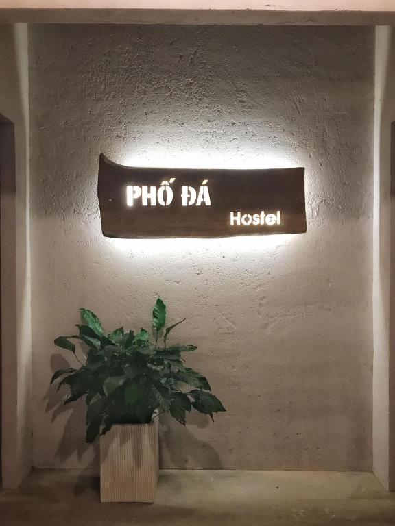 a sign that reads pho bar hospital with a potted plant at Phố Đá Hotel in Lagi