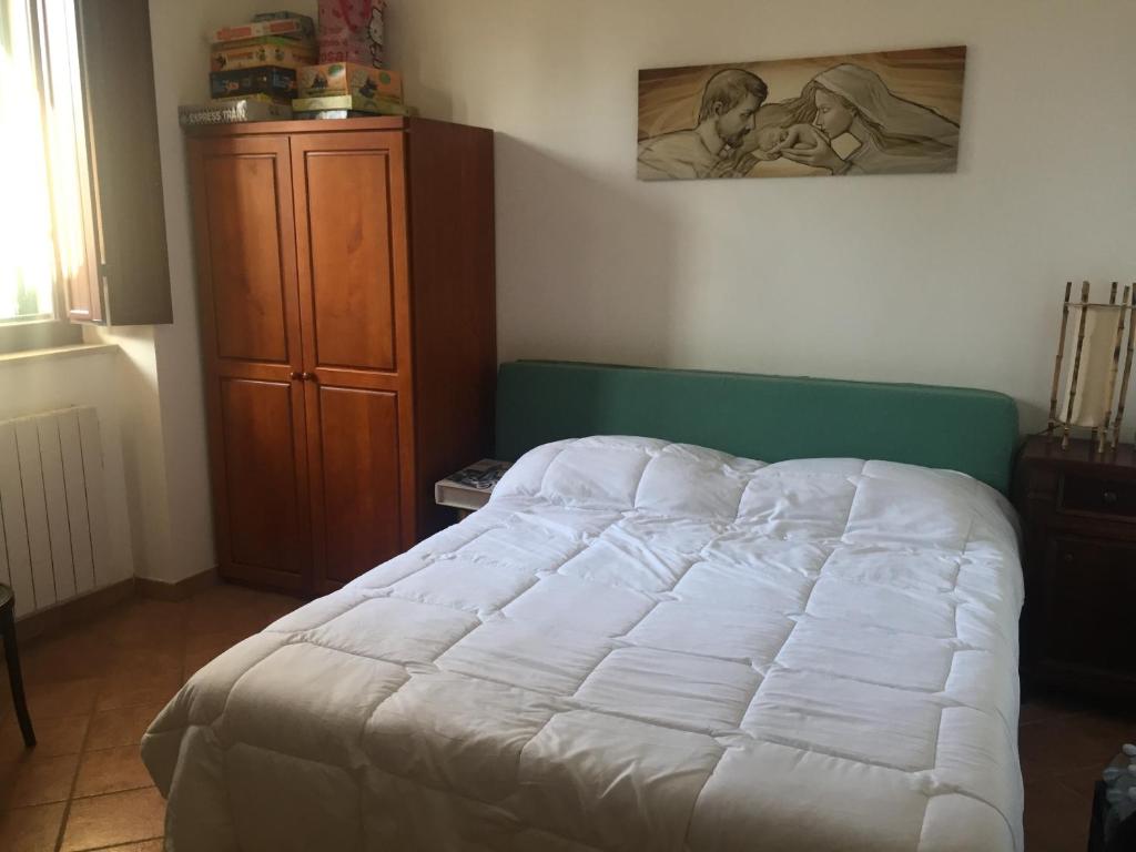 - une chambre avec un lit blanc et une armoire en bois dans l'établissement Casa delle Fate, à Scicli
