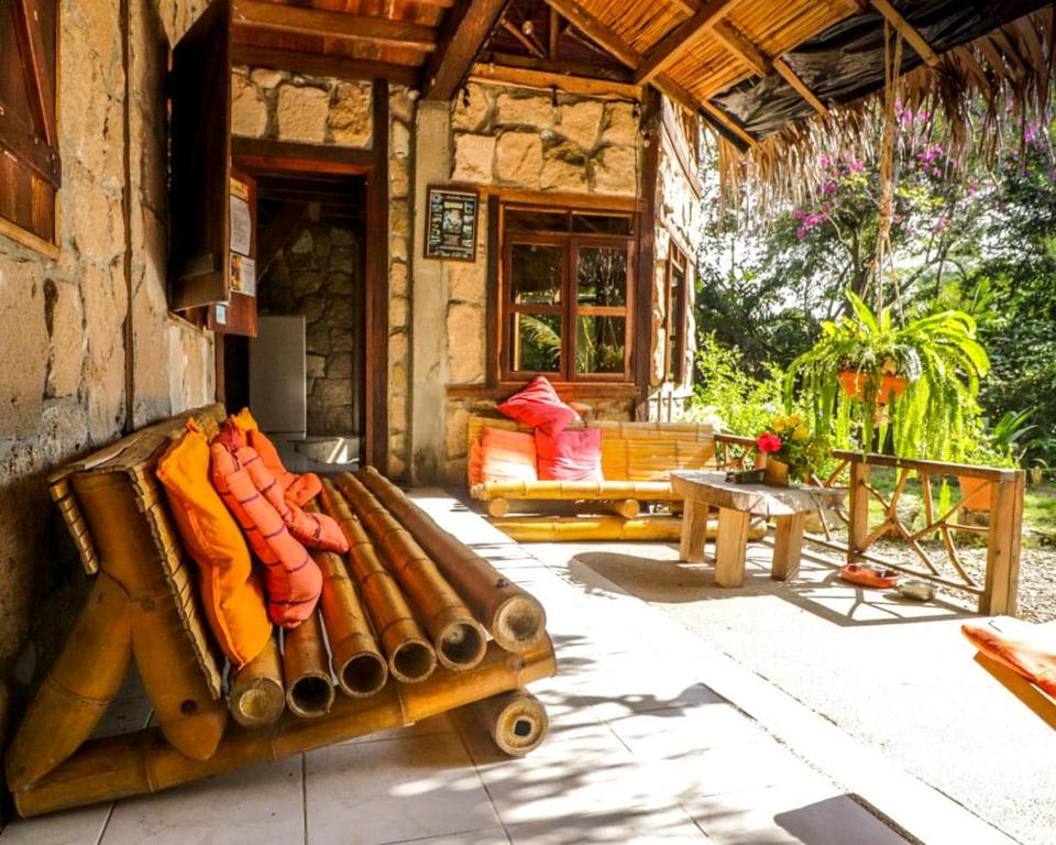 a porch of a house with a couch and a table at Las Cabañas de la Iguana in Ayampe
