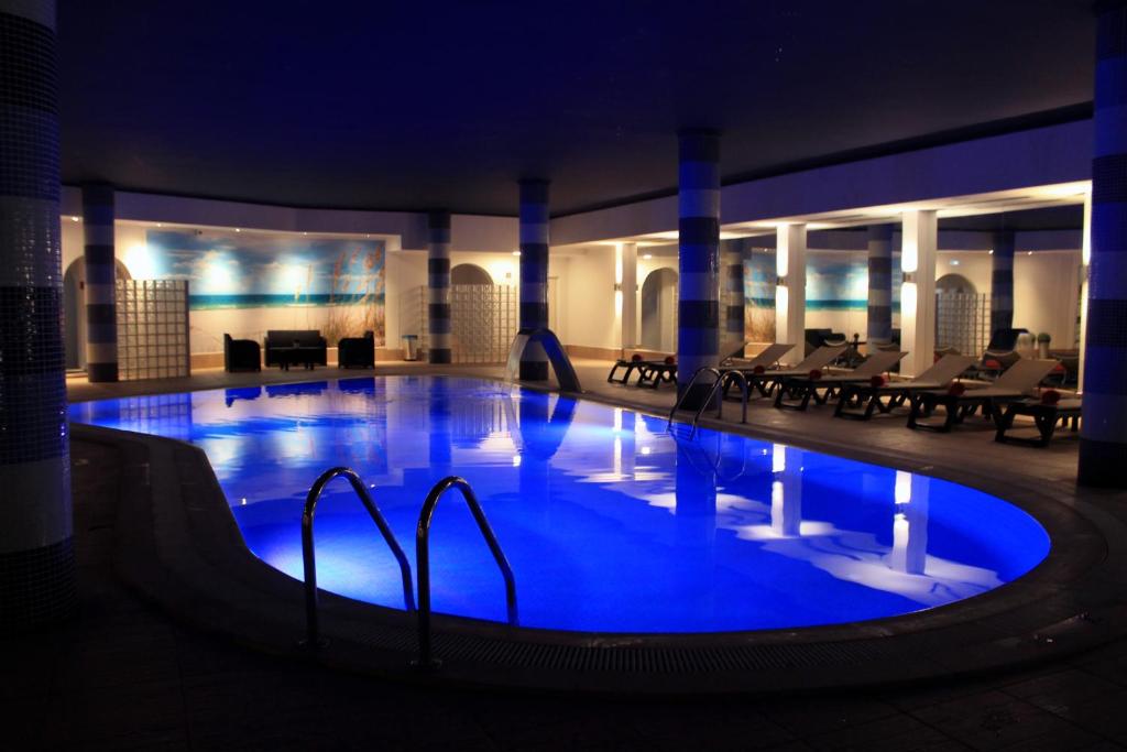 a large swimming pool with blue lighting in a hotel at The Navigator - Solaqua in Albufeira