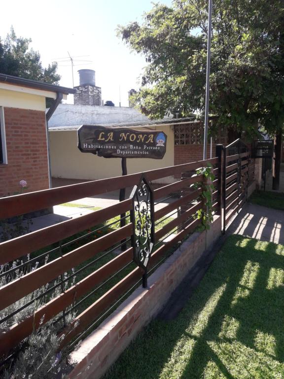 una valla delante de un edificio con una señal en La Nona en Villa Cura Brochero
