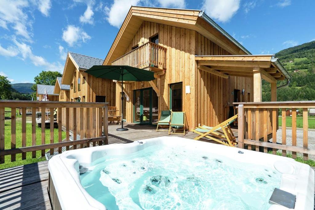 a hot tub on a deck with a house at Hirsch Chalet in Sankt Lorenzen ob Murau