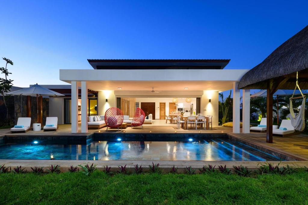 a villa with a swimming pool in front of a house at Luxurious Villa - Beach 1039m, Golf & Malls 4mn in Grand Baie