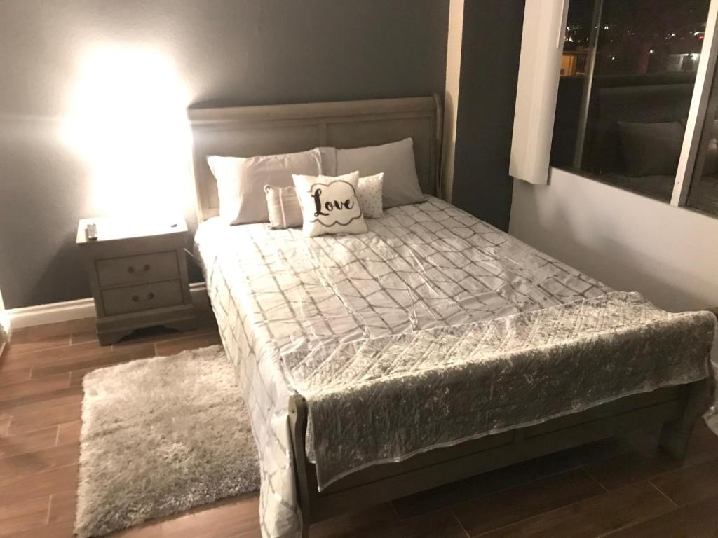 a bedroom with a bed with a pillow that reads love at Amazing Spare Bedroom in Shared 2/B Condo behind Convention Center in Las Vegas