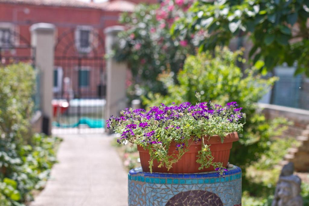 una olla de flores sentada en la parte superior de un poste en Ca' Del Pomo Grana' Al Roman, en Murano