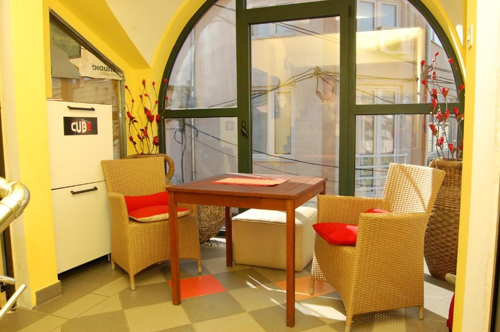 a room with a table and chairs and a refrigerator at Apartments Iva in Kragujevac