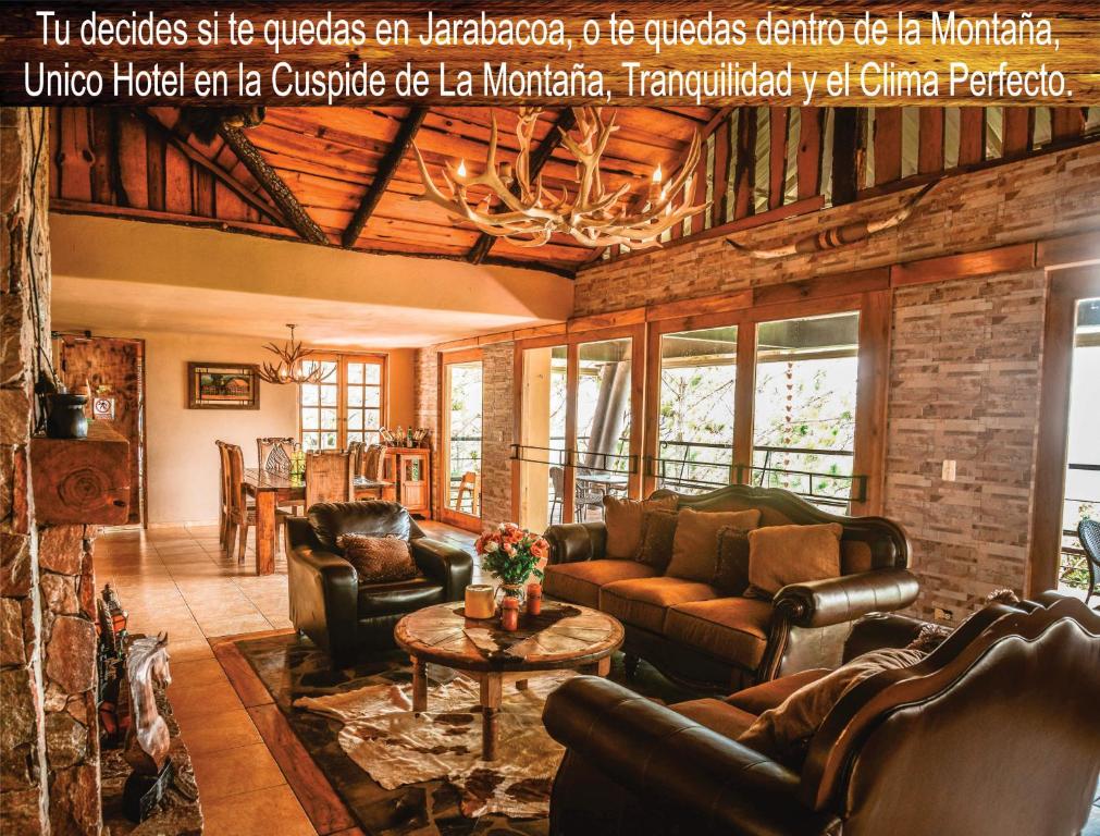 a living room with leather furniture and a fireplace at Rancho Tierra Alta in Jarabacoa