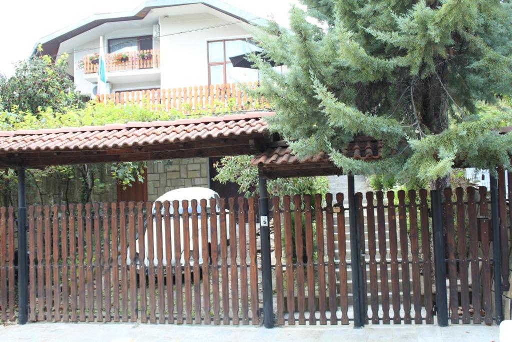 a fence in front of a house with a building at Къща за гости-"Борики"-Габрово in Gabrovo