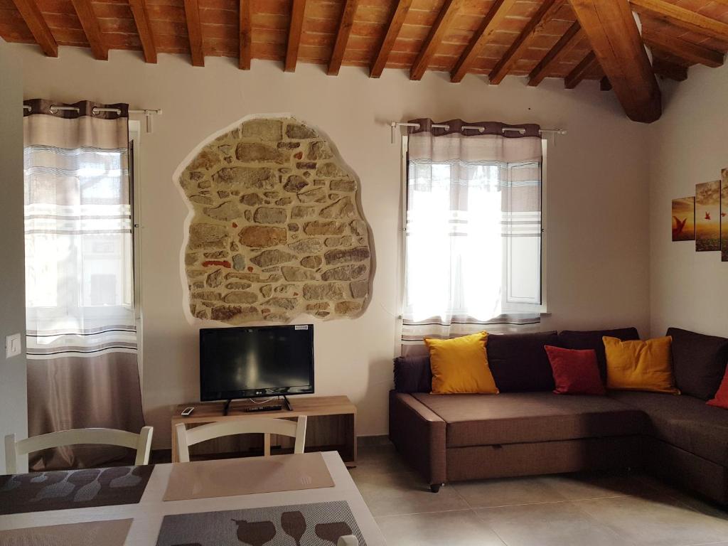 sala de estar con sofá y TV en Vicus House en Viciomaggio