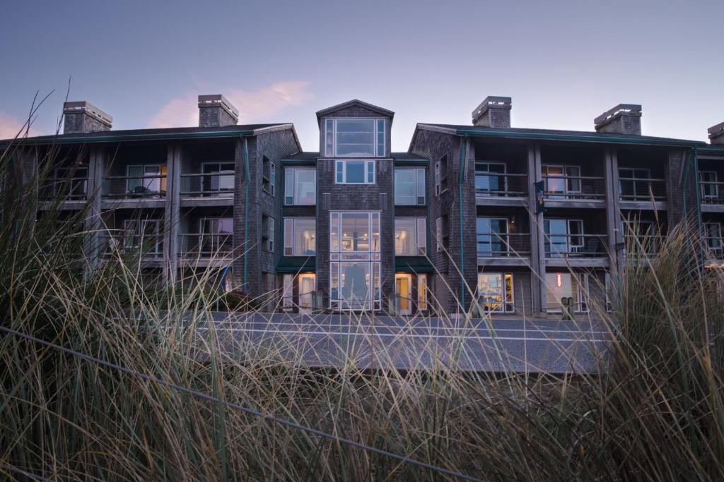 an apartment building with tall grass in front of it at Inn at Cape Kiwanda in Pacific City