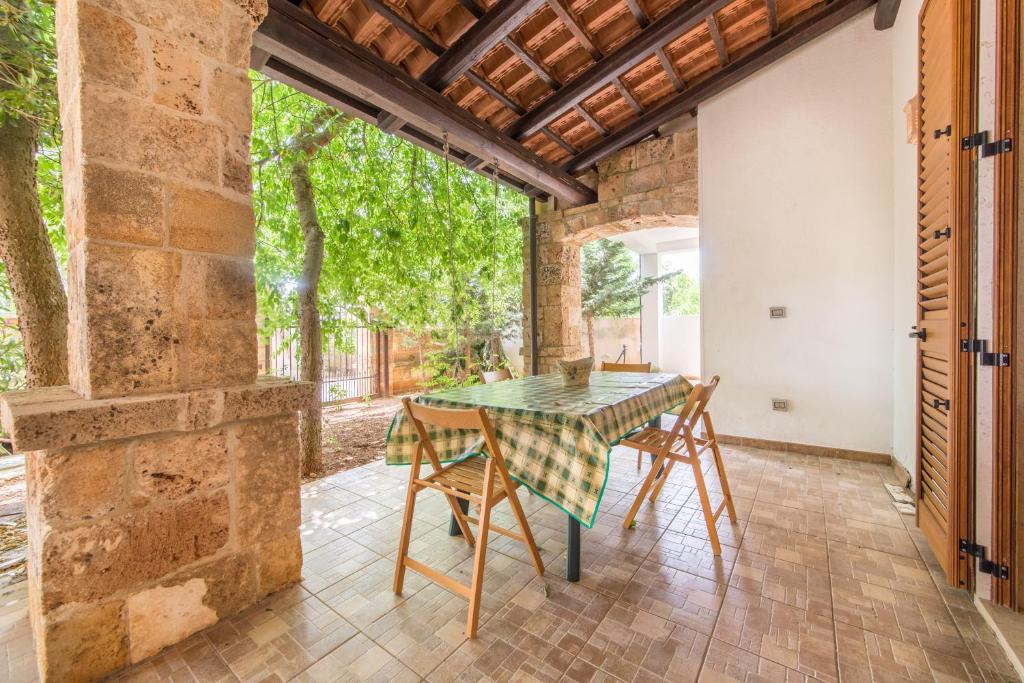 una sala da pranzo all'aperto con tavolo e sedie di Residence San Martino a Marina di Mancaversa