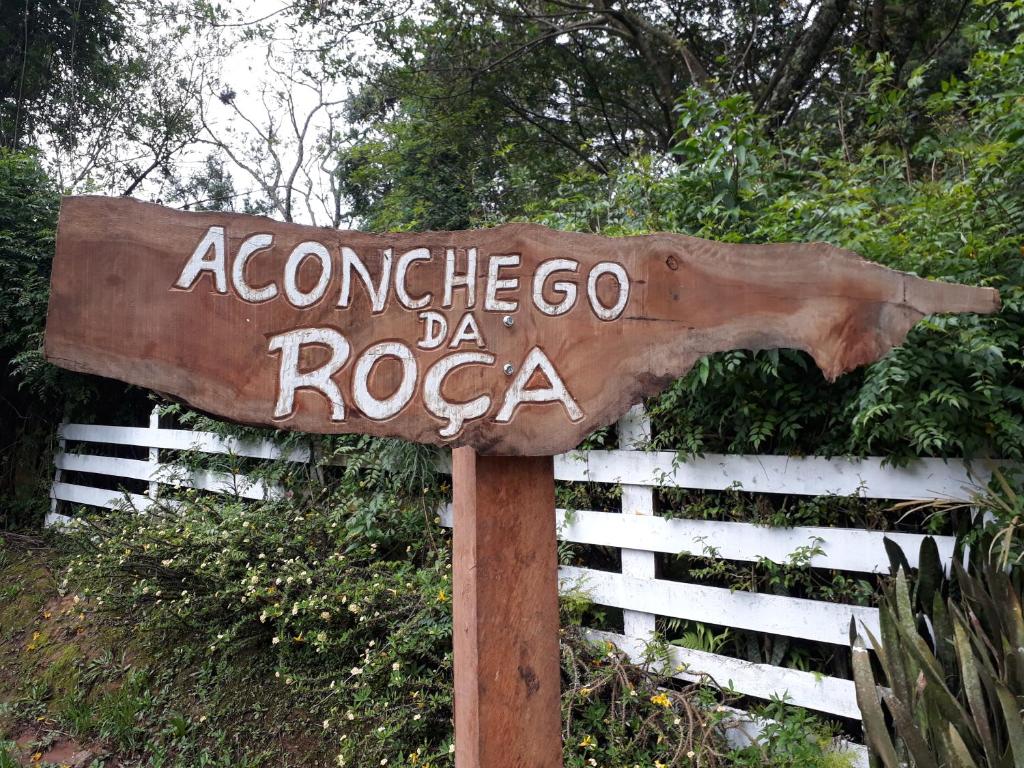 un panneau indiquant saysaccooco para rocca devant une clôture dans l'établissement Aconchego da Roça, à Gonçalves