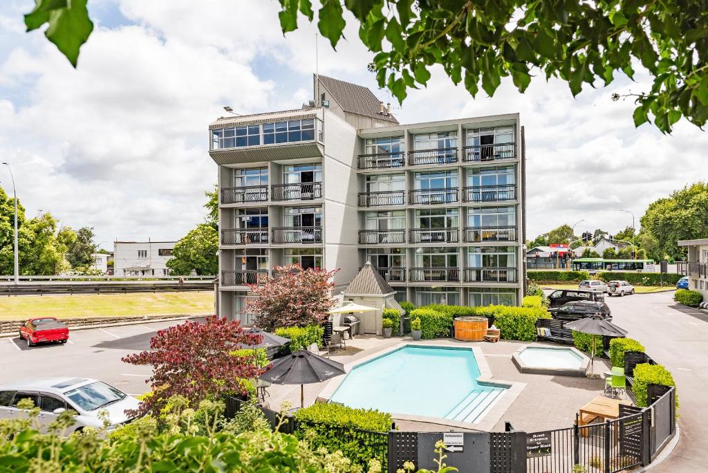 an apartment building with a pool and a parking lot at Heartland Ambassador Hotel Hamilton in Hamilton