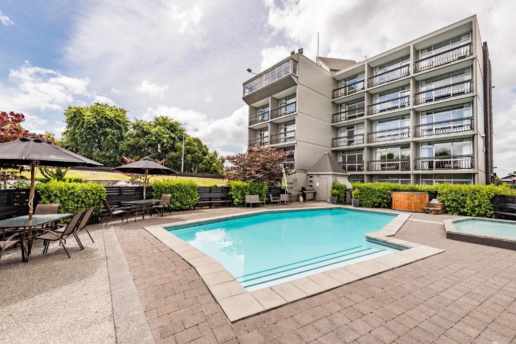 an image of a swimming pool in front of a building at Heartland Ambassador Hotel Hamilton in Hamilton