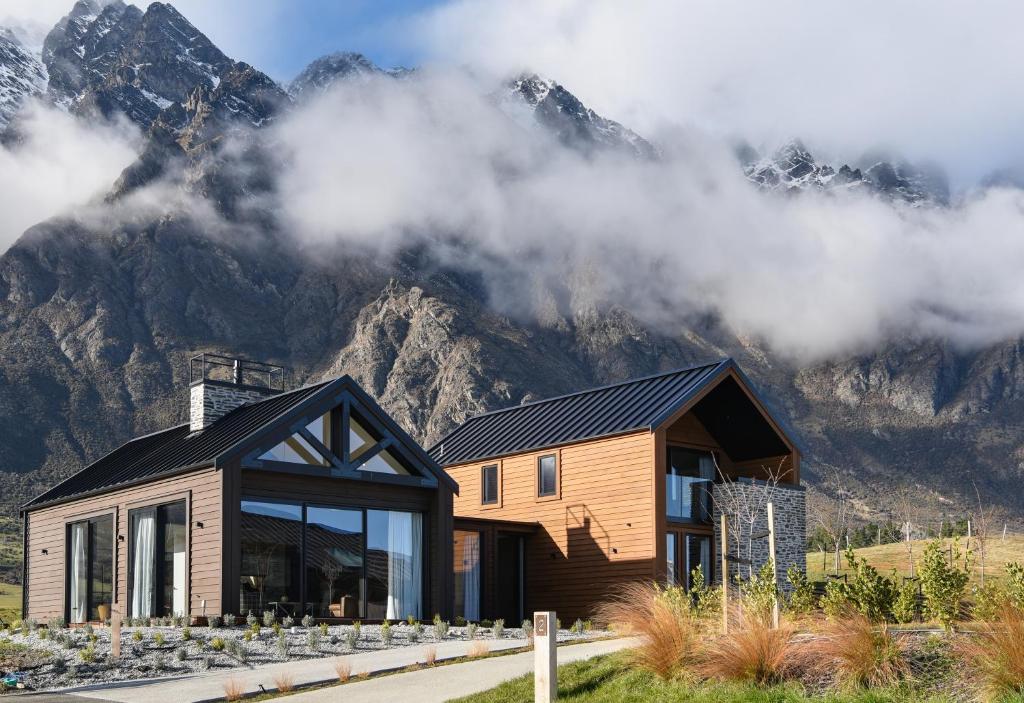 a wooden house with mountains in the background at 4 Stockyard Lane in Queenstown