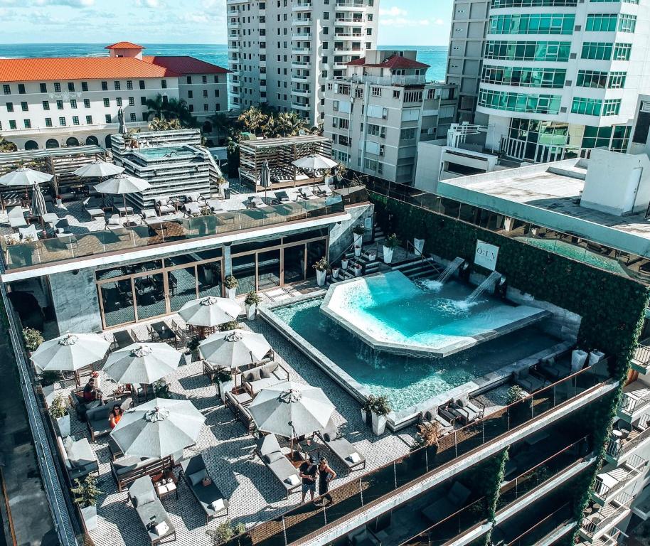 an overhead view of a pool with umbrellas and tables at O:LV Fifty Five Hotel - Adults Only in San Juan