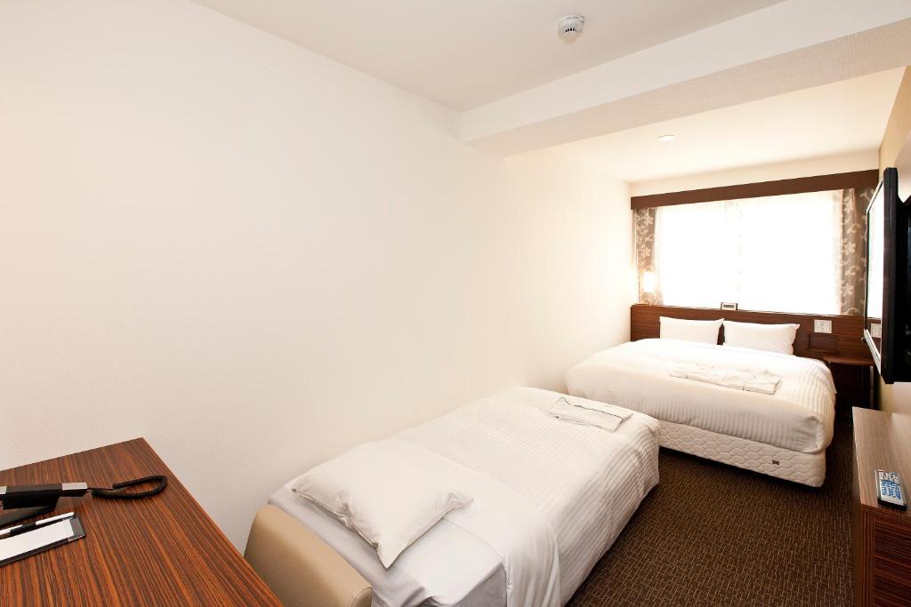 Postel nebo postele na pokoji v ubytování Sotetsu Fresa Inn Tokyo Tamachi