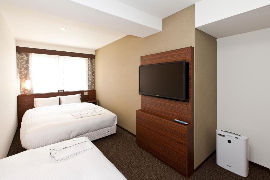 Postel nebo postele na pokoji v ubytování Sotetsu Fresa Inn Tokyo Tamachi