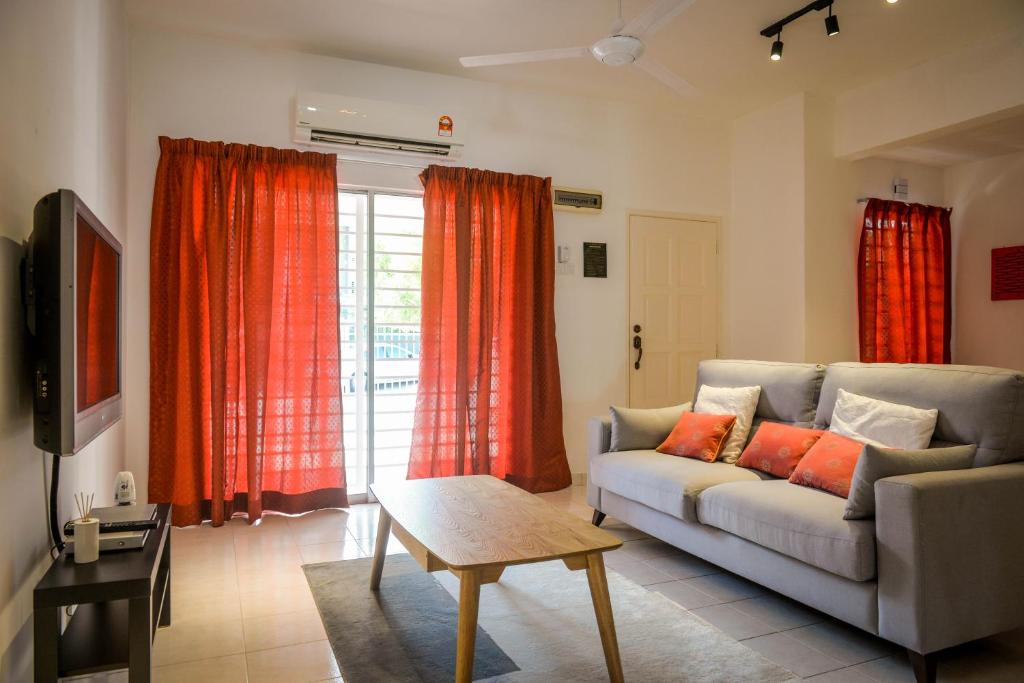 a living room with a couch and red curtains at BNB Cozy Homestay - Emerald West Rawang in Rawang