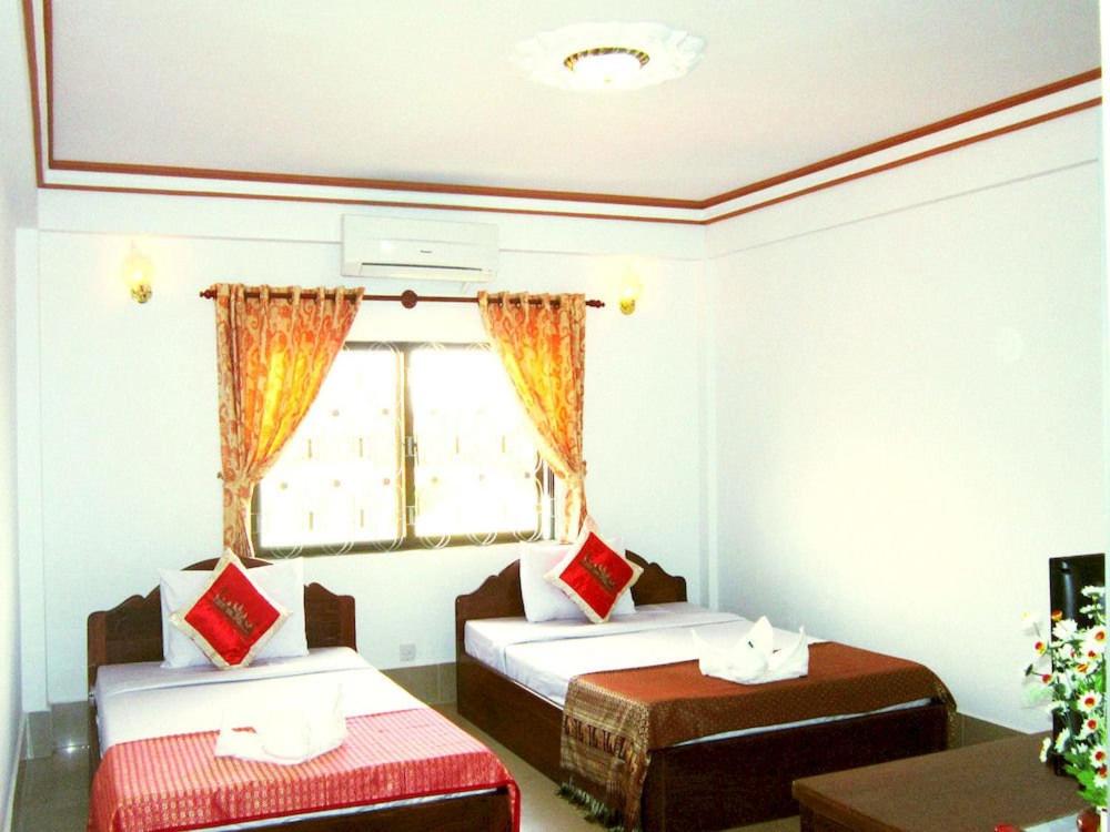 Habitación con 2 camas y ventana en Angkor Ruby Guesthouse, en Siem Reap