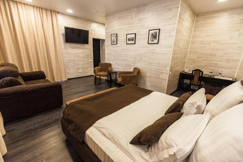 バルナウルにあるFox Hotelの大きなベッドとソファが備わるホテルルームです。