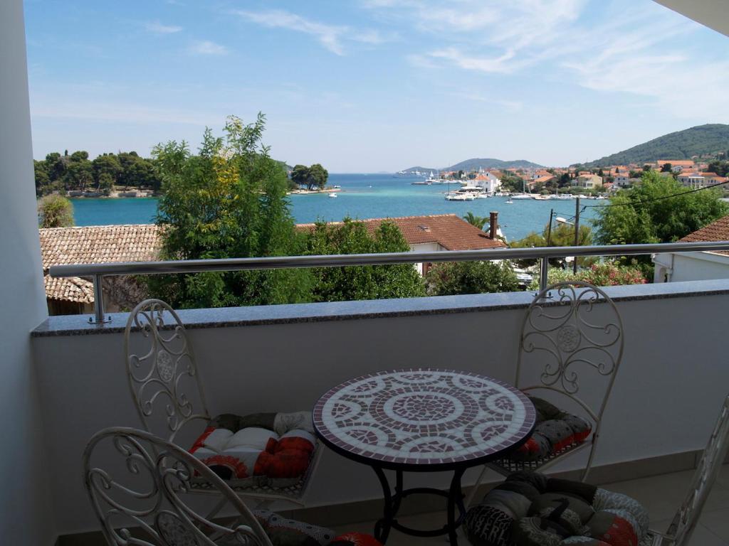 a balcony with a table and chairs and a view of the water at Villa Majer in Preko