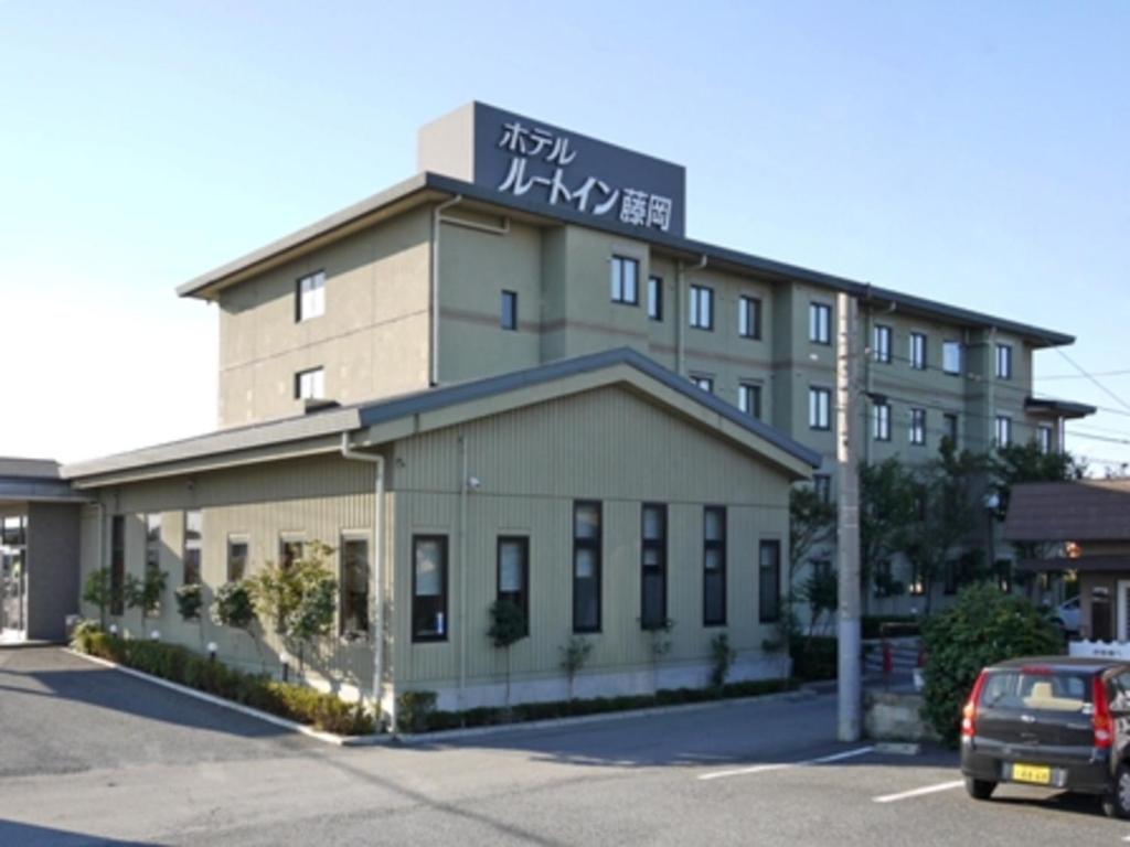 un edificio con un cartel en la parte superior en Hotel Route-Inn Court Fujioka, en Fujioka