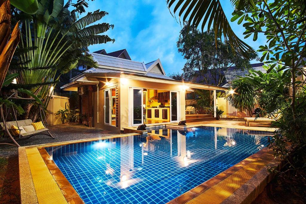 a swimming pool in front of a house at Baan Manuchang Villa, SHA Certified in Ao Nang Beach