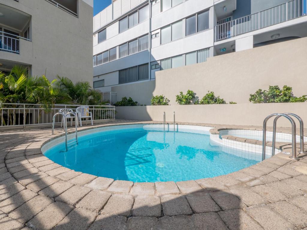 a swimming pool in front of a building at Seaspray U4 21 Warne Tce in Caloundra