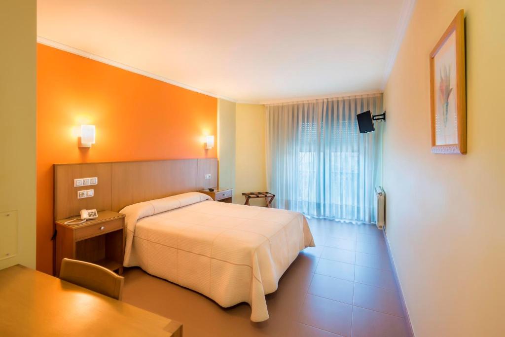 a hotel room with a bed and a window at Hotel O Cruceiro in Caldas de Reis