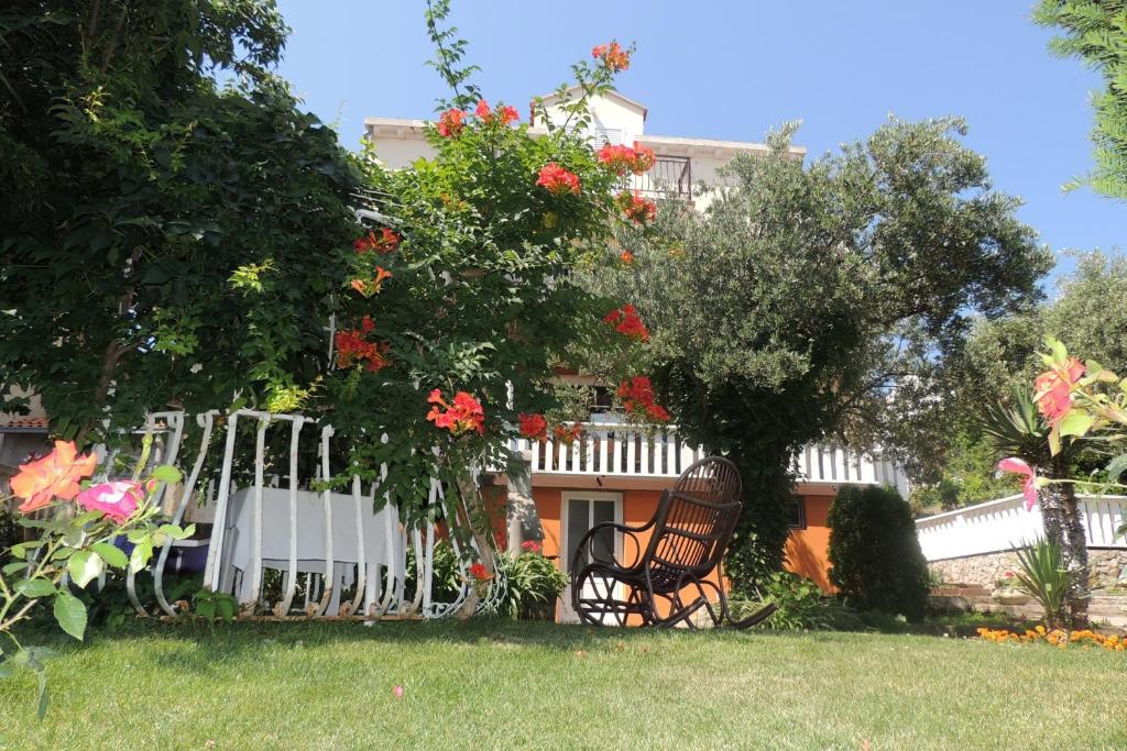 a garden with a white fence and red flowers at Apartments Travarevic in Dubrovnik
