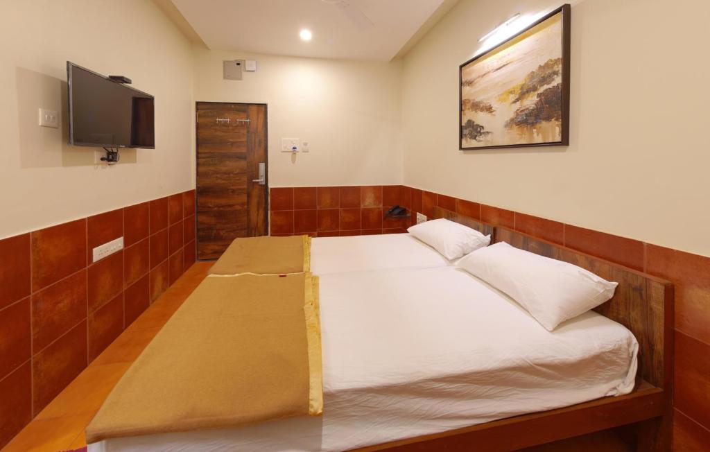 Giường trong phòng chung tại Hotel Parag Deluxe Kolhapur
