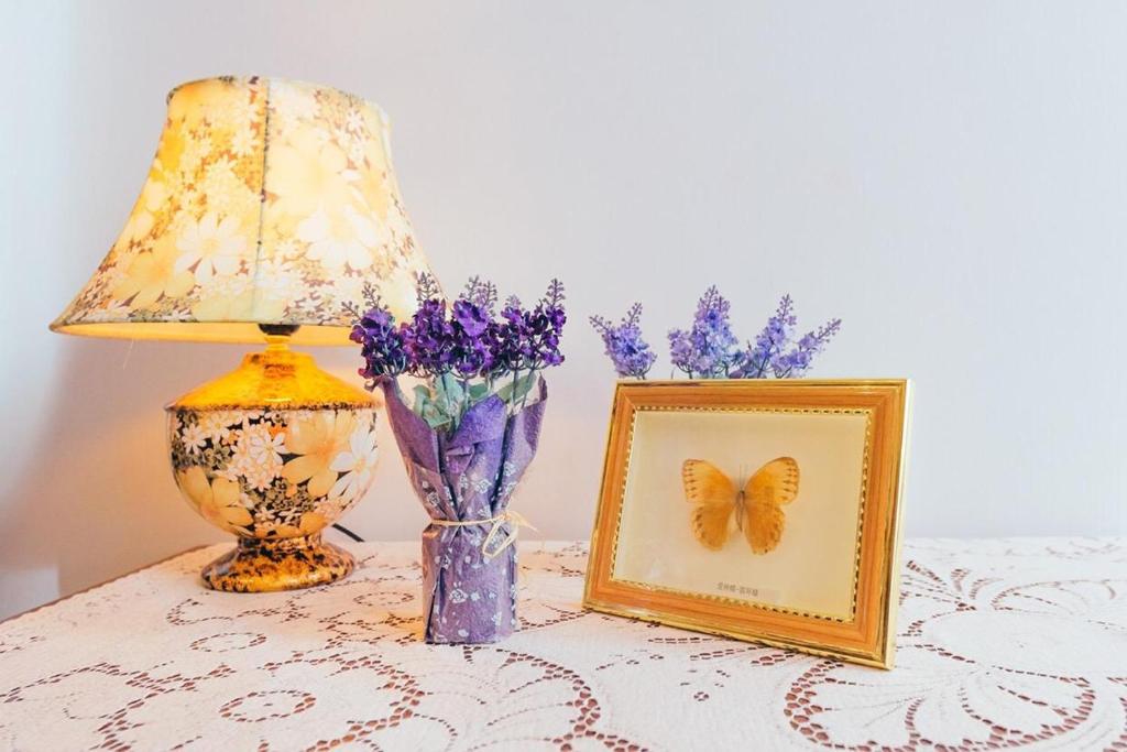 a table with a lamp and a picture and a butterfly at Vintage Apartment 2 rooms with Balcony in Lviv