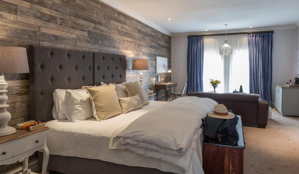 a bedroom with a large bed with a brick wall at 58 On Hume in Johannesburg