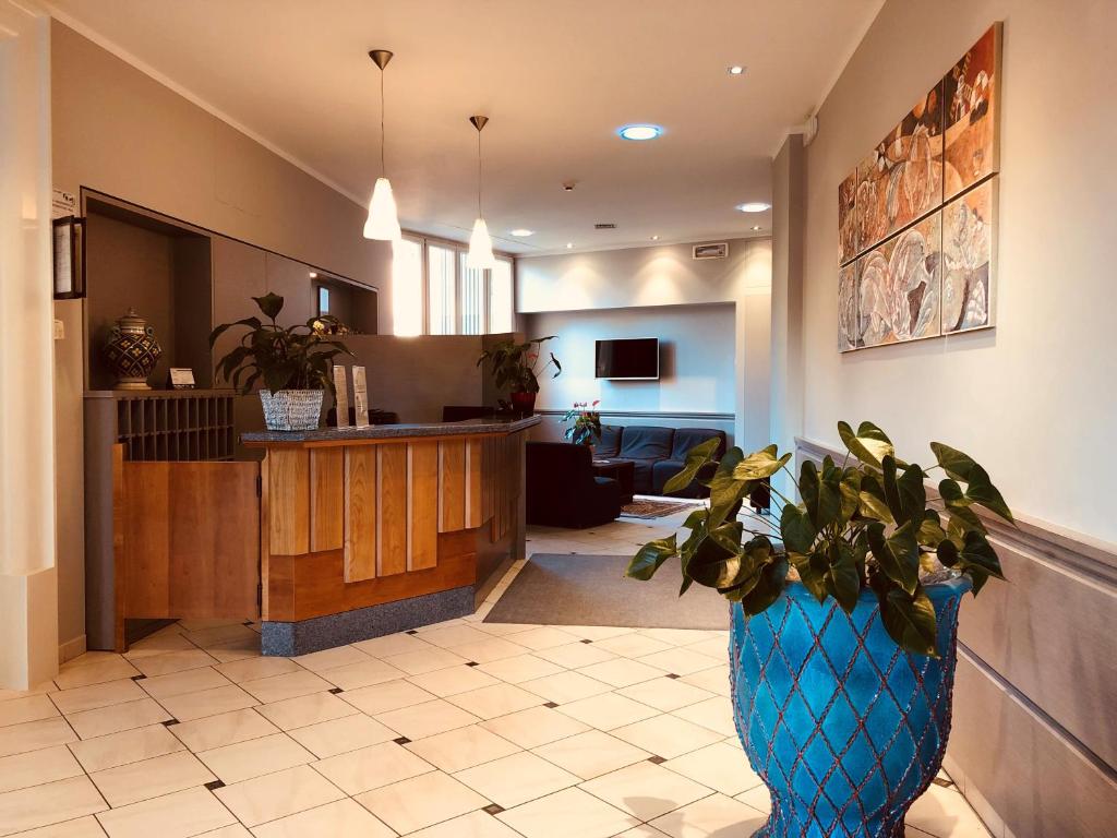 a hospital lobby with a blue vase with a plant at Hotel Delfina in Signa