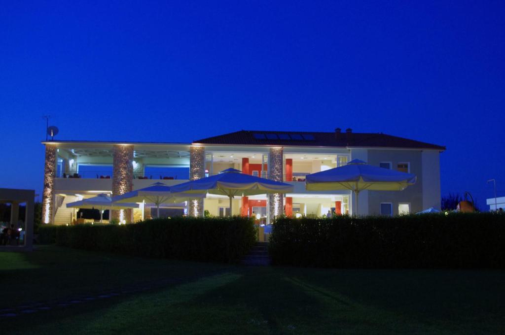 a building with umbrellas in front of it at night at Antonios Village Hotel & Apartments in Arkoudi