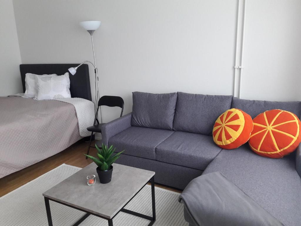 ein Wohnzimmer mit einem Sofa und einem Tisch in der Unterkunft Hamina Orange Apartments Kadetti 1 in Hamina