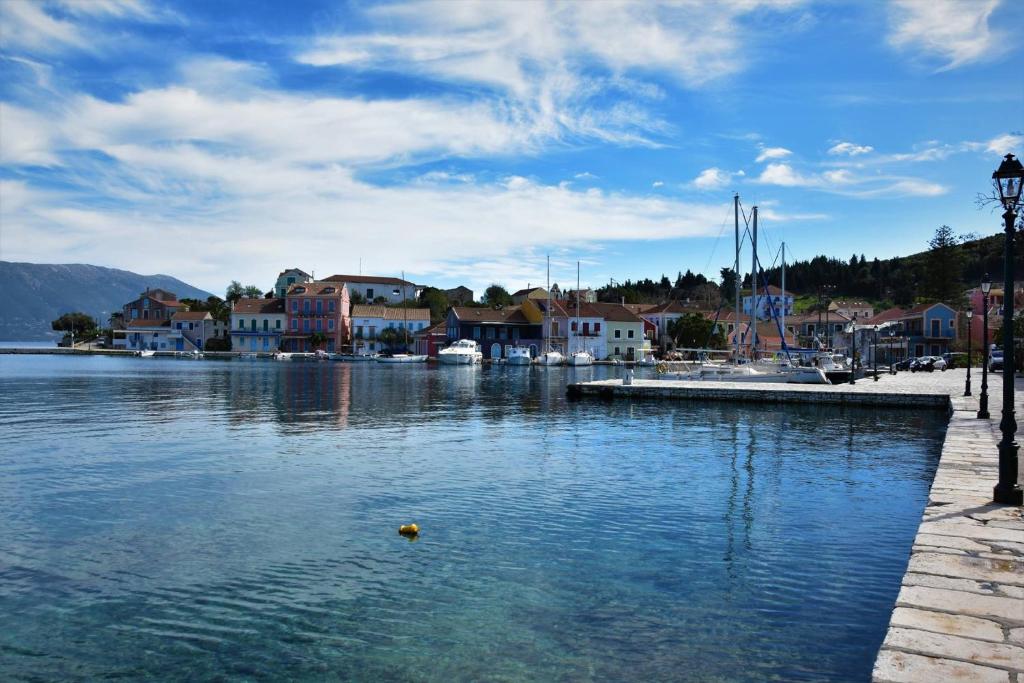 a body of water with houses and boats in it at Dafnoudi Hotel Apartments in Fiskardo