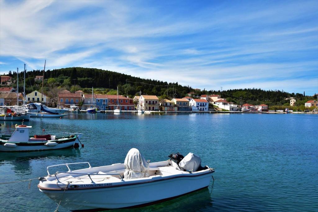 a white boat is docked in a body of water at Dafnoudi Hotel Apartments in Fiskardo