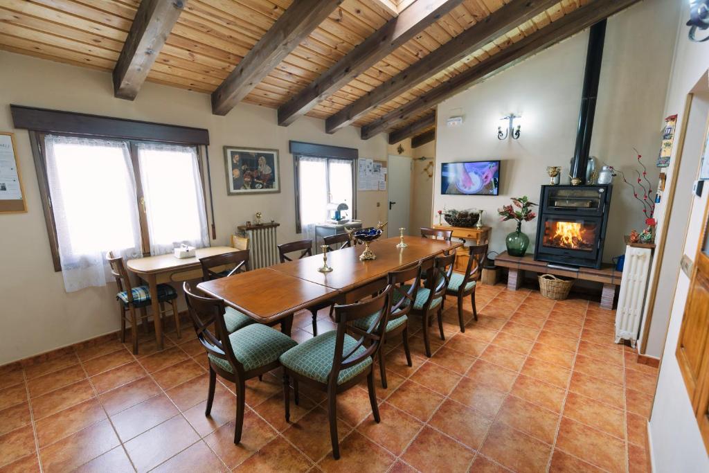 comedor con mesa, sillas y chimenea en Casa Rural Laguna Negra 49, en San Leonardo de Yagüe