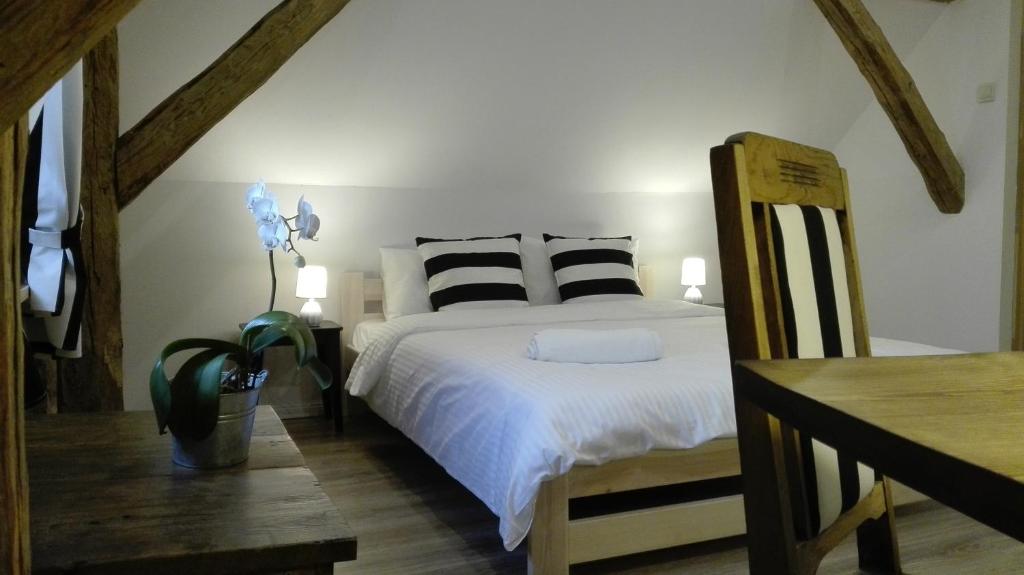 a bedroom with a bed with black and white pillows at Zacisze Kalwy in Kalwy