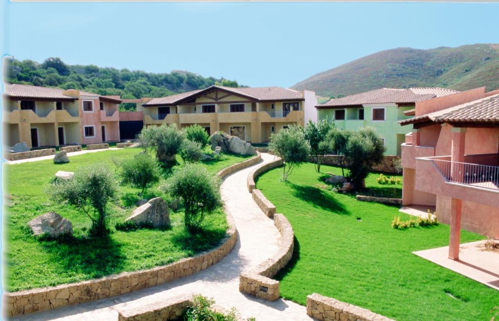 a view of a village with houses and a lawn at Le Corti di Marinella in Golfo Aranci