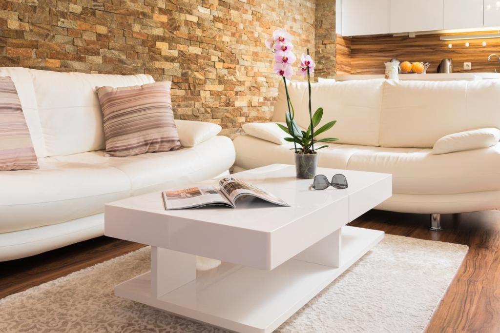 a living room with white furniture and a white coffee table at Nice and cozy flat in the center in Sofia