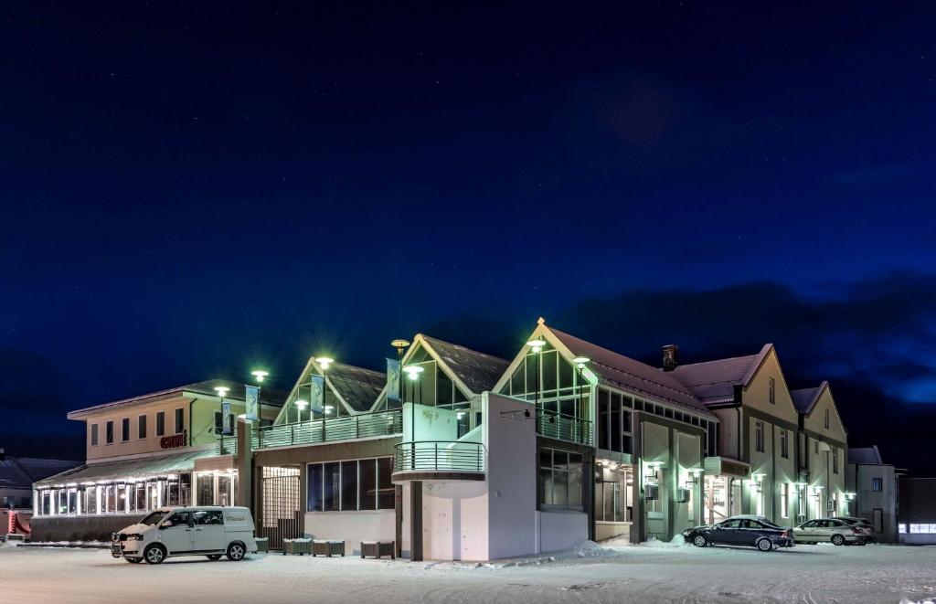 a building with cars parked in a parking lot at night at Melbu Hotell in Melbu