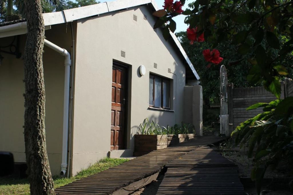 Casa blanca pequeña con puerta de madera en Hope's Rest 1 en Richards Bay