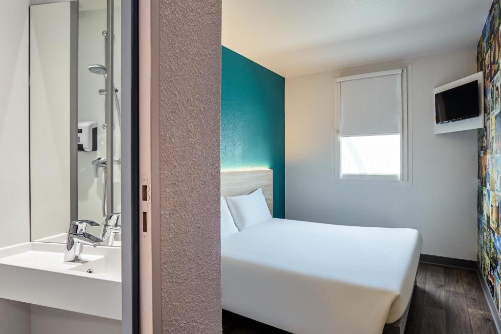 Pokój hotelowy z łóżkiem i umywalką w obiekcie hotelF1 Villemomble w mieście Villemomble