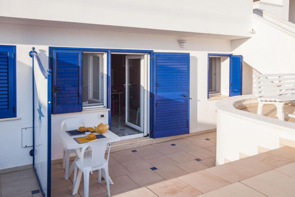 una stanza con porte blu e tavolo e sedie di Ampio monolocale al mare nel Salento Ionio m604 a Torre Vado
