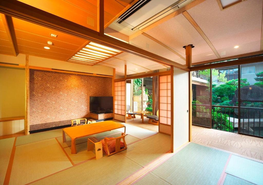 d'un salon avec une table et une télévision sur un balcon. dans l'établissement Meitei no Yado Hotel Koshien, à Fuefuki