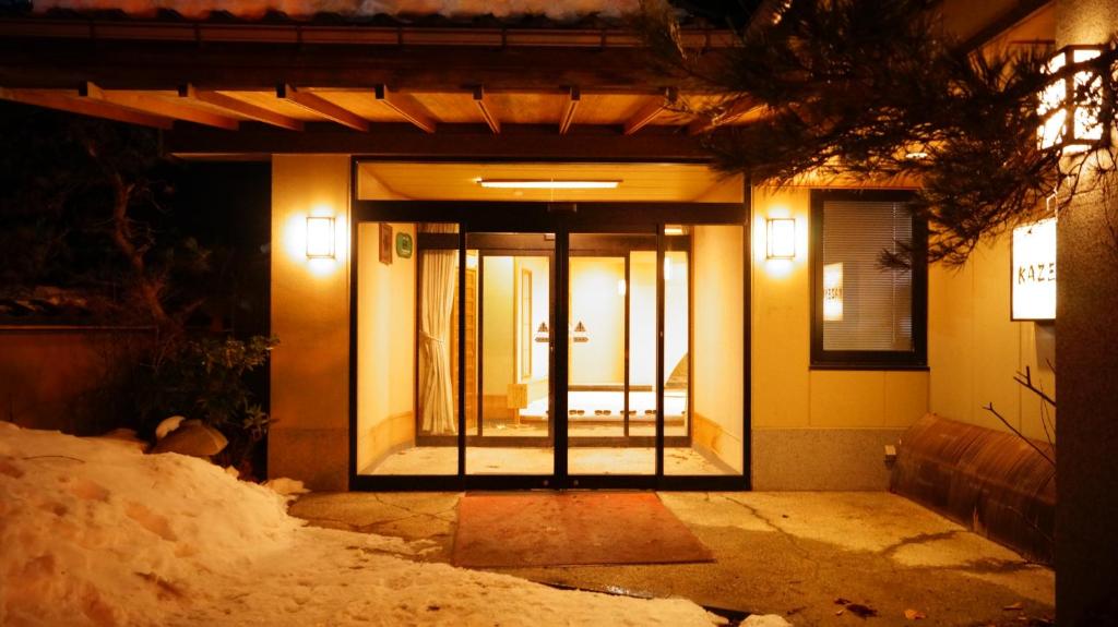 una porta d'ingresso di una casa con la neve intorno di Tabist Kazeyuki a Takayama