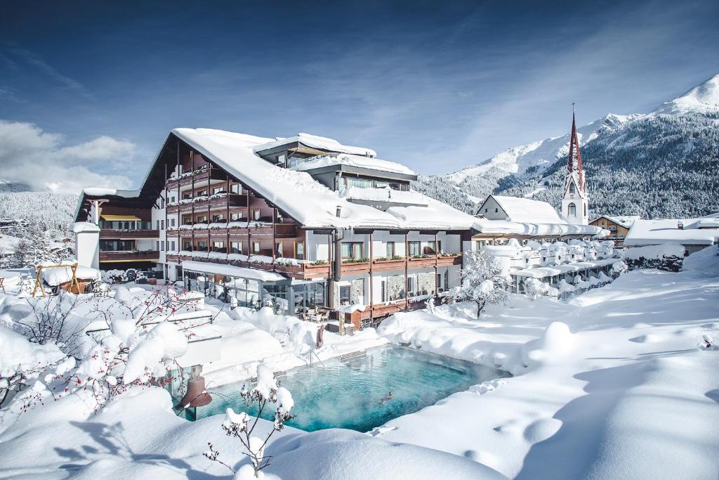 ein schneebedecktes Gebäude mit einem Pool in der Unterkunft Hotel Klosterbräu in Seefeld in Tirol